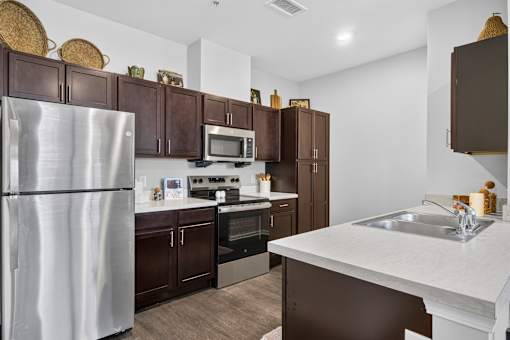 A kitchen with a white counter top and brown cabinets.
