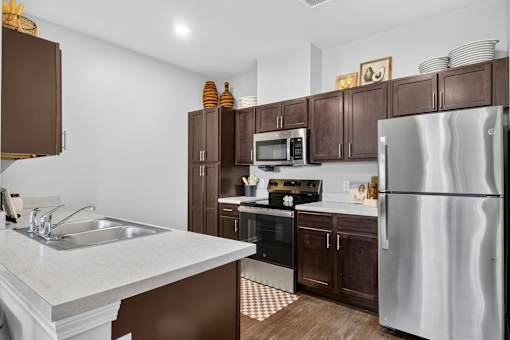 A modern kitchen with dark brown cabinets and stainless steel appliances.