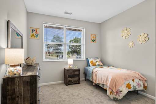 A bedroom with a bed, nightstands, and a window.