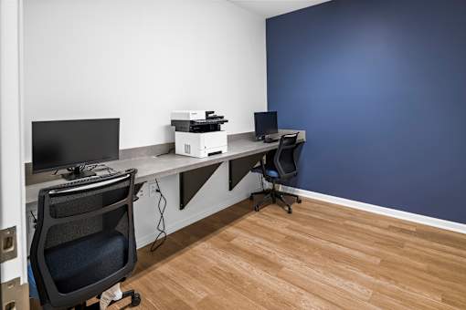 a office with a desk with a computer and a printer on it