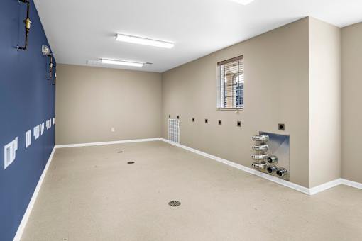 an empty room with a window and a blue wall and a white floor