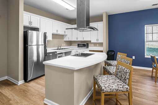 a kitchen with a white counter top and a stainless steel refrigerator