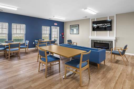 a community room with a table and chairs and a fireplace