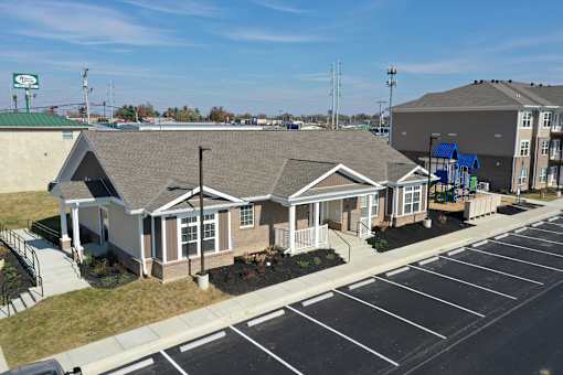a group of houses in a parking lot next to a building