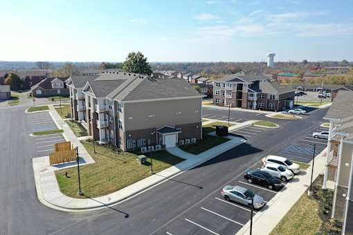 an aerial view of an apartment complex with cars parked in a parking lot