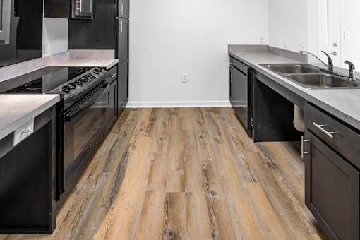a kitchen with stainless steel appliances and wooden floors