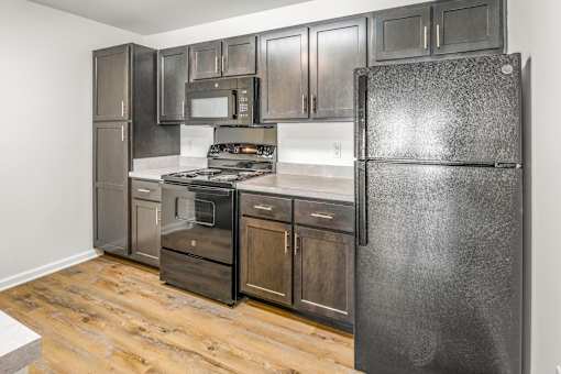 a kitchen with stainless steel appliances and wooden floors