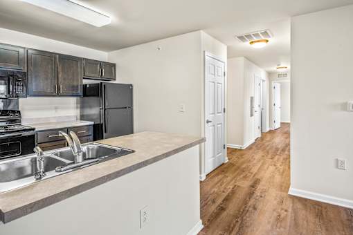 an empty apartment with a kitchen and a pass through to the living room