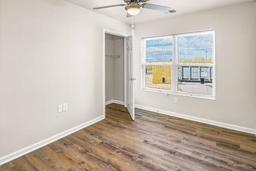 an empty bedroom with a window and a door to a closet