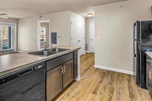 a kitchen with wooden floors and a sink and a refrigerator