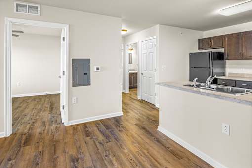 a kitchen and living room with wood flooring and an open doorway