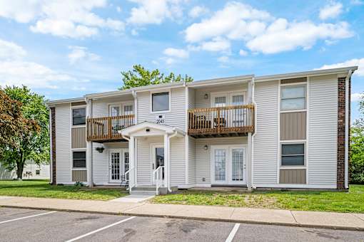 A two-story apartment building with a balcony on the second floor.
