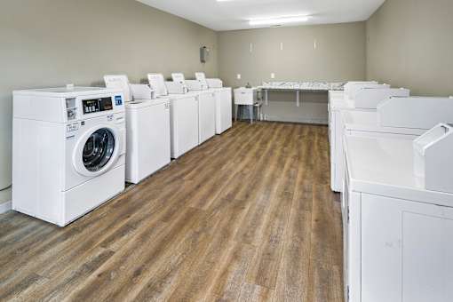 A laundry room with a washer and dryer on the left and a dishwasher on the right.
