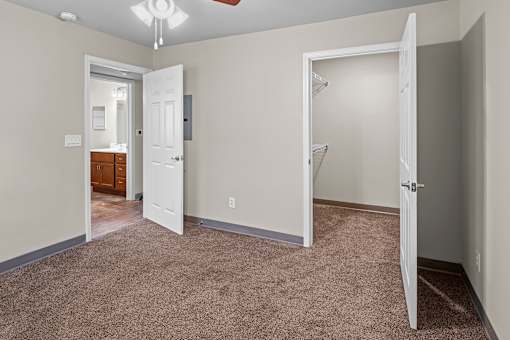 A room with a carpeted floor and a white door.