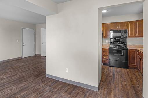 A kitchen with a black stove top oven and wooden cabinets.