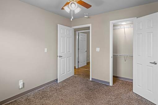 A room with a ceiling fan and two doors.