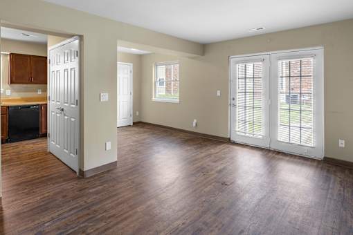 A large empty room with wooden floors and white walls.