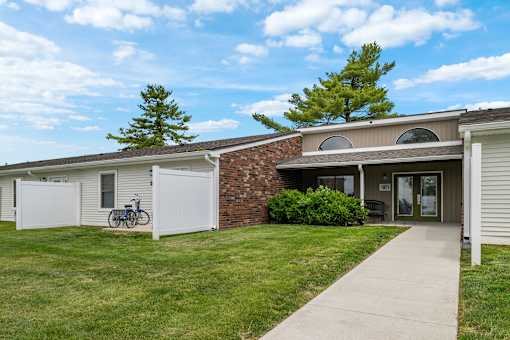 A house with a white garage door and a bicycle parked outside.