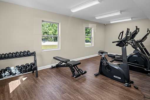 A home gym with a bench, weights, and exercise equipment.