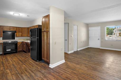 A kitchen with wood floors and white walls.