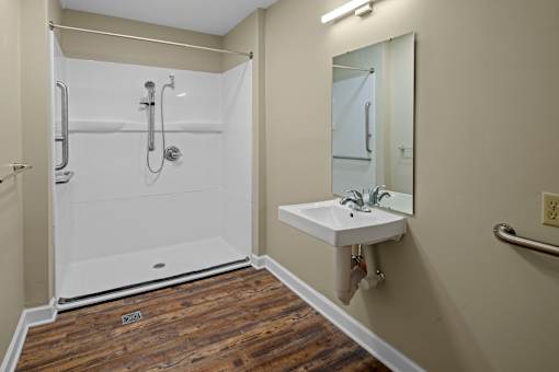 A white sink is mounted on a wall next to a mirror in a bathroom.