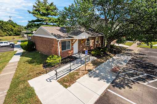 A small brick house with a metal fence in front.