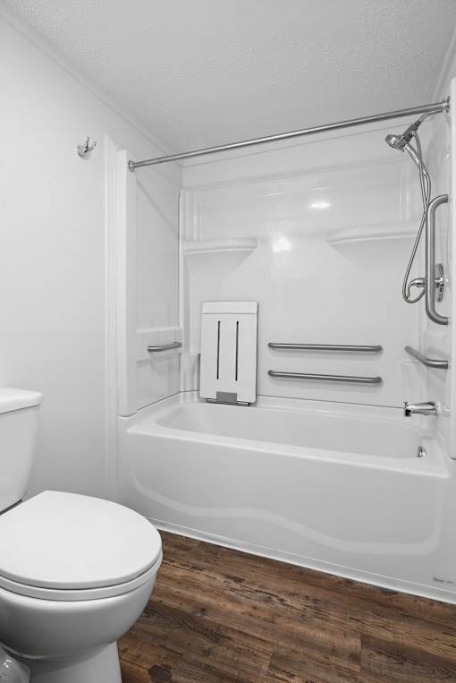 A white toilet sits next to a white bathtub in a bathroom.