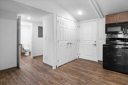 A kitchen area with a black oven and white cabinets.