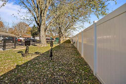 A white fence runs along the side of a gravel path.