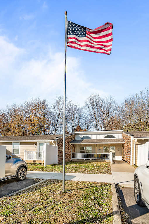 A house with a flag on a pole in front of it.