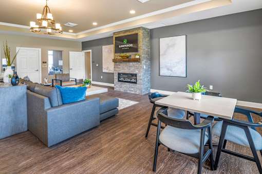 A modern living room with a grey sofa, a wooden dining table, and a fireplace.