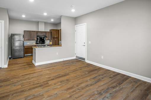 A kitchen with a refrigerator, cabinets, and a countertop.