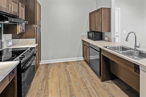 A kitchen with wooden floors and a black stove top oven.