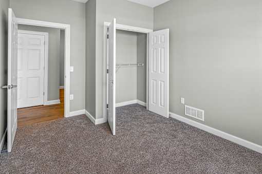 A room with two white doors and a carpeted floor.