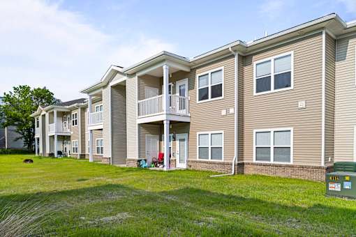 A large apartment complex with a grassy area in front.