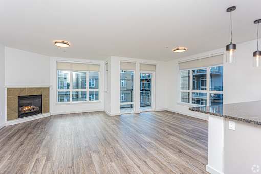 A spacious living room with a fireplace and large windows.