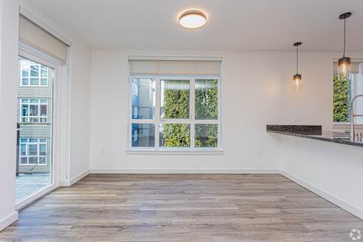 A room with a large window and wooden flooring.