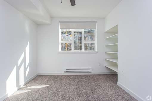 A room with a window and a bench.