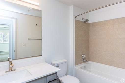 A white bathroom with a toilet, sink, and bathtub.