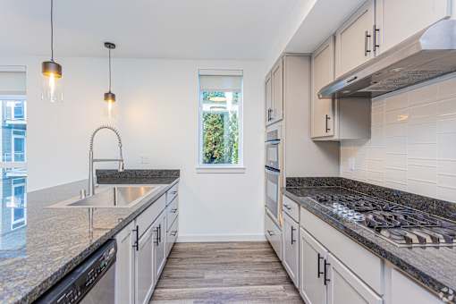 A kitchen with granite countertops and stainless steel appliances.