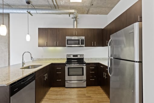 a kitchen with stainless steel appliances and a marble counter top at The Parker Apartments, Oregon, 97209
