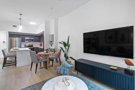 a living room with a large tv and a table with chairs at One Plantation in FL 33324