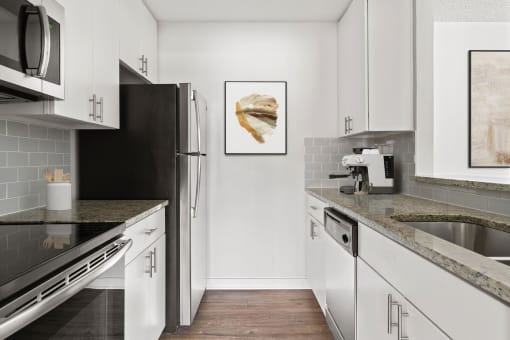 a modern kitchen with stainless steel appliances and marble counter tops