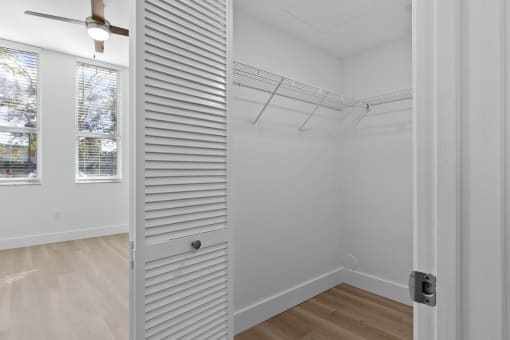 a closet in a bedroom with white walls and wood floors at One Plantation in Plantation, FL