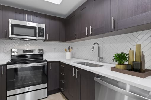 a kitchen with stainless steel appliances and a sink at One Plantation in Plantation, 33324