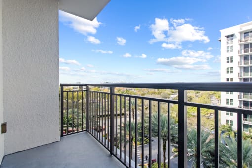 the view from the balcony of a condo with a blue sky and palm trees at One Plantation in FL 33324