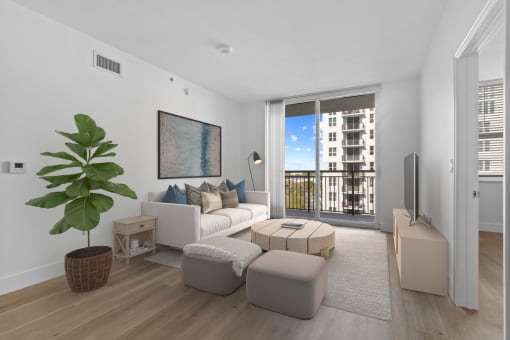 a living room with a white couch and a large plant at One Plantation in Plantation, FL