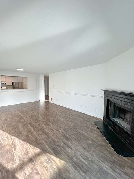 A room with a fireplace and wood flooring at 2000 Lake Washington Apartments, WA, 98056