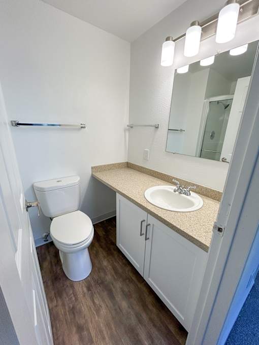 A white toilet sits in a small bathroom next to a sink at 2000 Lake Washington Apartments, Renton, Washington, 98056