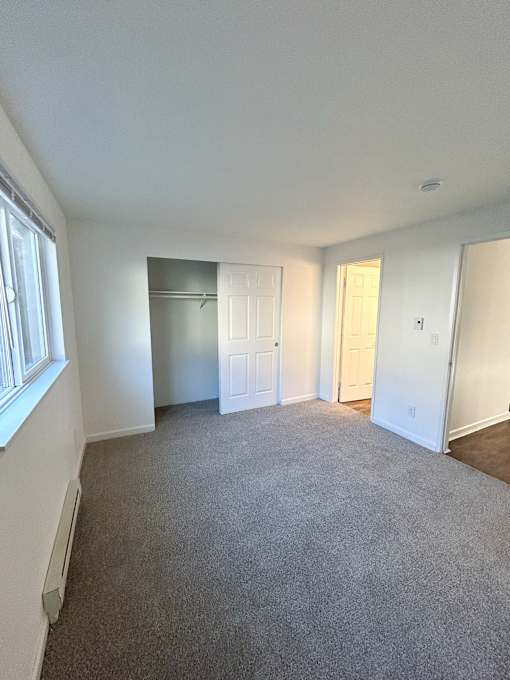 A room with white walls and a grey carpet at 2000 Lake Washington Apartments, Renton, 98056